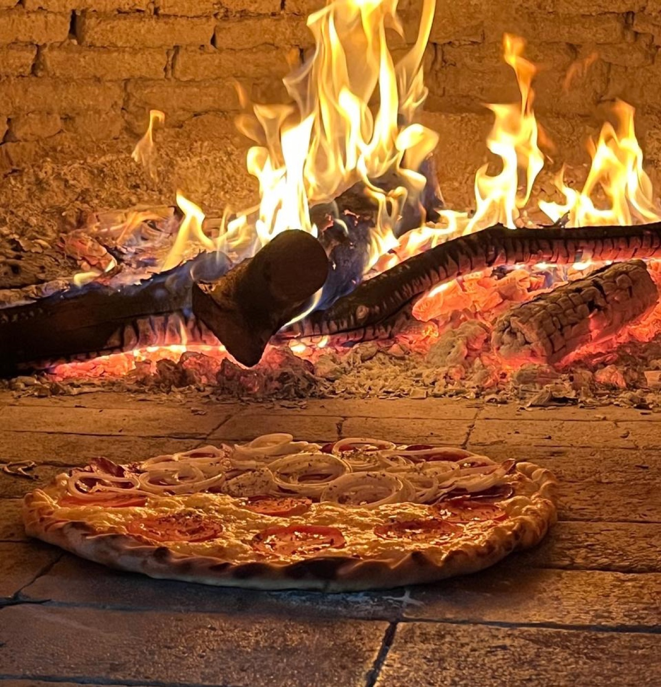 Pizza assando no forno a lenha da Danluthi